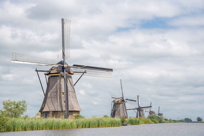 Traditional windmills on field against sky