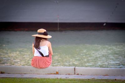 Rear view of woman sitting on umbrella