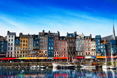 Boats moored in canal against buildings in city