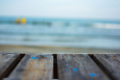 Close-up of wooden pier over sea against sky