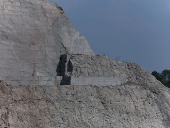 Low angle view of rocky mountain against sky