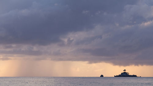 Scenic view of sea against  rainy sky during sunset at la digue, seychelles