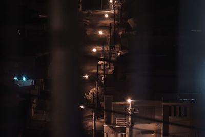 Illuminated street lights by buildings in city at night