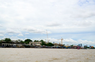 View of buildings in city against cloudy sky