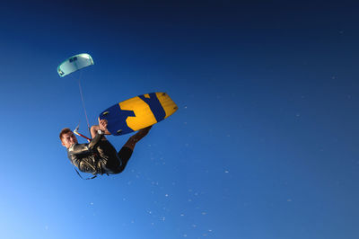 A kitesurfer rides while suspended in the air. kitesurfer jumps against a beautiful blue sky