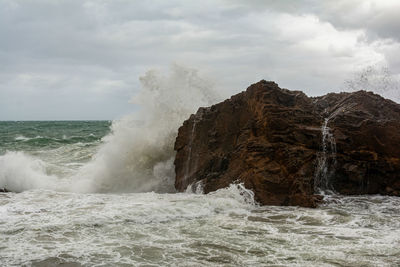 Sea waves crashing hard against a rock in winter. winter storm.