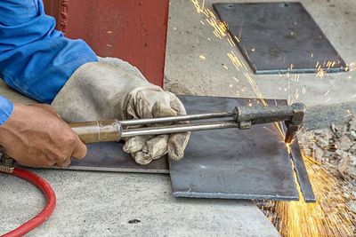 Cropped hands of worker welding metal