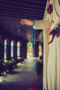 Close-up of rosary beads on statue at church