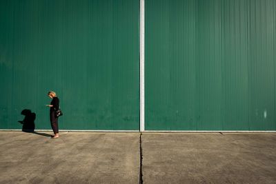 Full length of man standing against wall