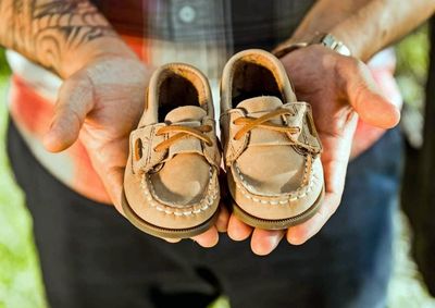 Close-up of man holding shoes