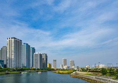 River amidst buildings in city against sky