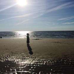 Silhouette man standing on beach against sky during sunset