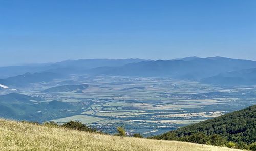 Scenic view of field and mountains against sky