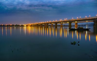 Bridge over river against sky at night