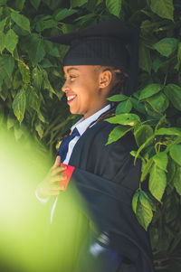 Young man smiling while standing amidst leaves