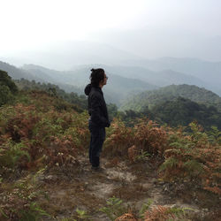 Rear view of woman standing on mountain