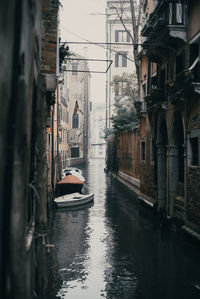 Boats in canal amidst buildings