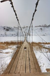 Snow covered land against sky during winter