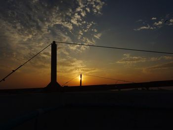 Silhouette bridge against sky during sunset