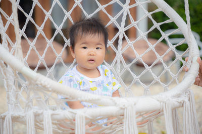 Portrait of cute girl sitting in swing