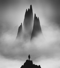 Low angle view of silhouette mountain against cloudy sky