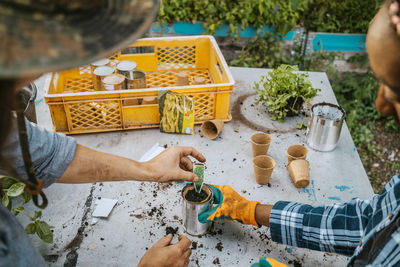 Cropped image of male and female environmentalists seedling at table