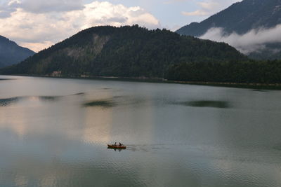 Scenic view of lake by mountains against sky