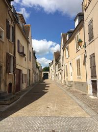 Empty road leading towards buildings