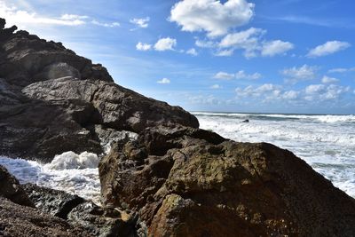 Scenic view of sea and rocks against sky