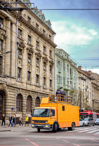 Cars on city street against sky