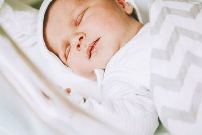 High angle view of baby sleeping on bed