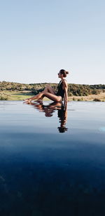 Full length of senior woman in water against clear sky