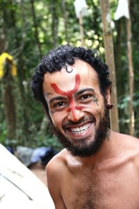 Portrait of smiling man with face paint against trees