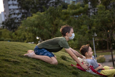 Rear view of two brothers  on grass