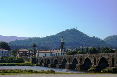 Arch bridge over river against clear sky