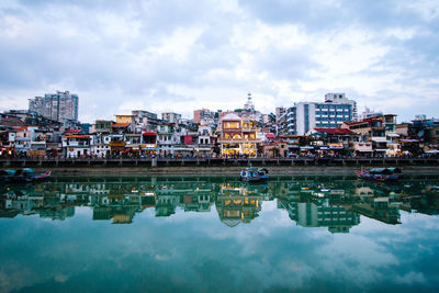 Reflection of buildings in river against sky