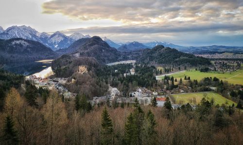 Scenic view of townscape by mountains against sky