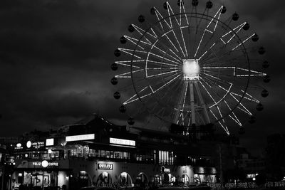 Low angle view of illuminated ferris wheel against sky at night
