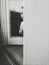 Close-up of boy looking through window