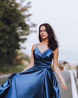 Young woman standing against trees