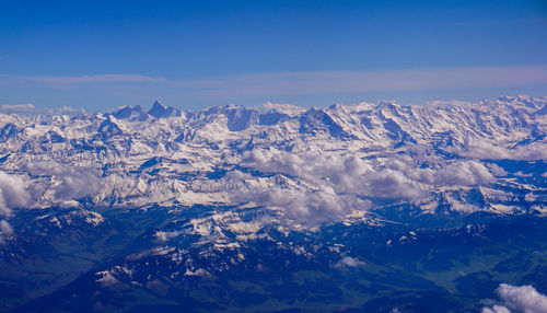 Scenic view of snowcapped mountains against blue sky