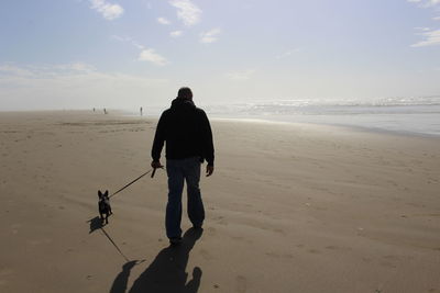 Rear view of man walking on beach