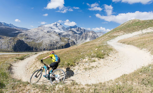 Downhill mountain biker in front of the grande motte glacier in summer in the vanoise massif