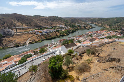 High angle view of city by river against sky