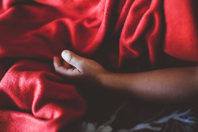 Close-up of woman hand on bed