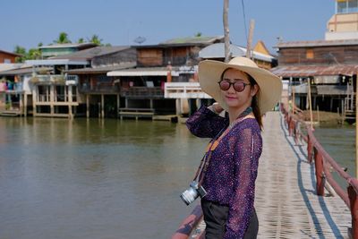 Woman wearing hat standing by canal