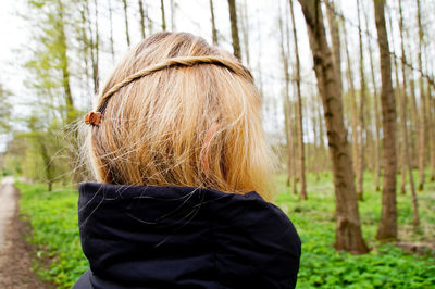 Rear view of child on tree trunk in forest