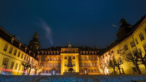 Low angle view of illuminated buildings against sky at night