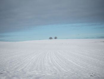 Scenic view of snow covered land against sky