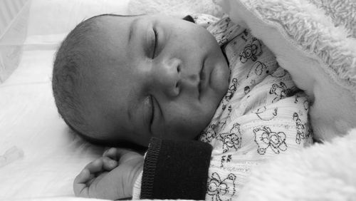 Close-up of baby boy sleeping in crib